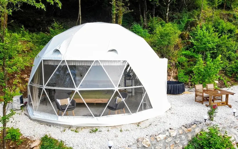 Geodesic glamping dome with a glass front and private jacuzzi at Zen Relaxing Village