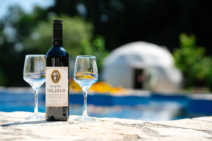 Đuraš wine and glasses with a glamping dome behind